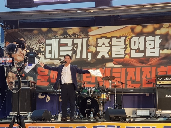 태극기와 촛불을 모두 들고 연단에 올라온 김한메 사세행 대표. (사진출처 : 변희재의 진실투쟁 카페) 